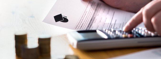A person's hand holds a piece of paper while the other hand types on a calculator on a desk.